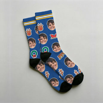 Calcetines de reno personalizados azules con la cara de un niño, entre astas, zanahorias, trineos y MODO RENO